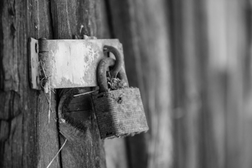 black and white pic of rusty lock on a barn door