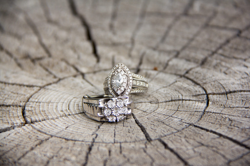 two wedding rings on cracked wooden stump