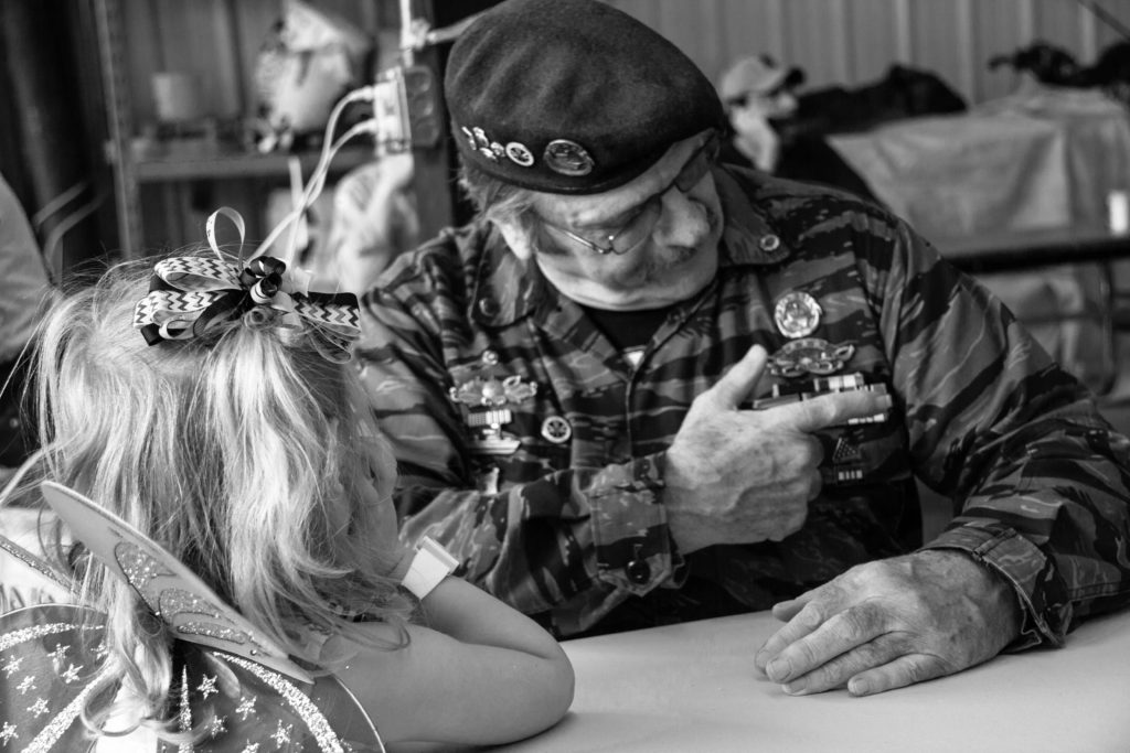 vietnam veteran showing his medals to a little girl