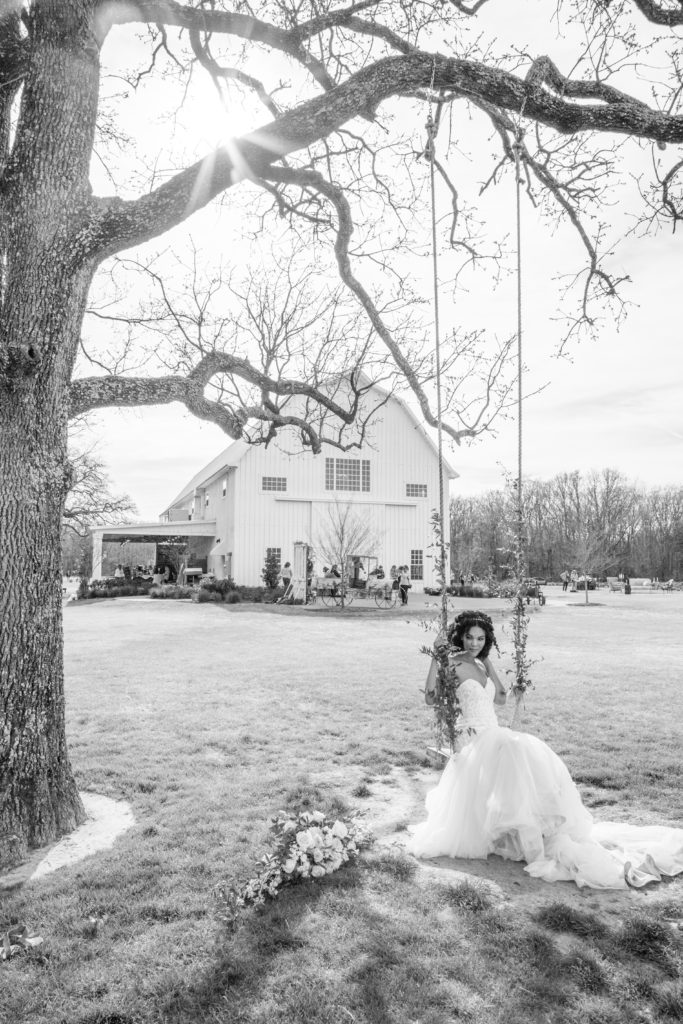 Beautiful bride swinging on a swing by White Sparrow Barn
