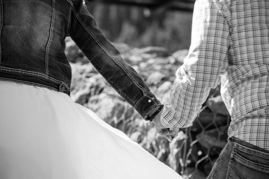 couple sneaking off holding hands