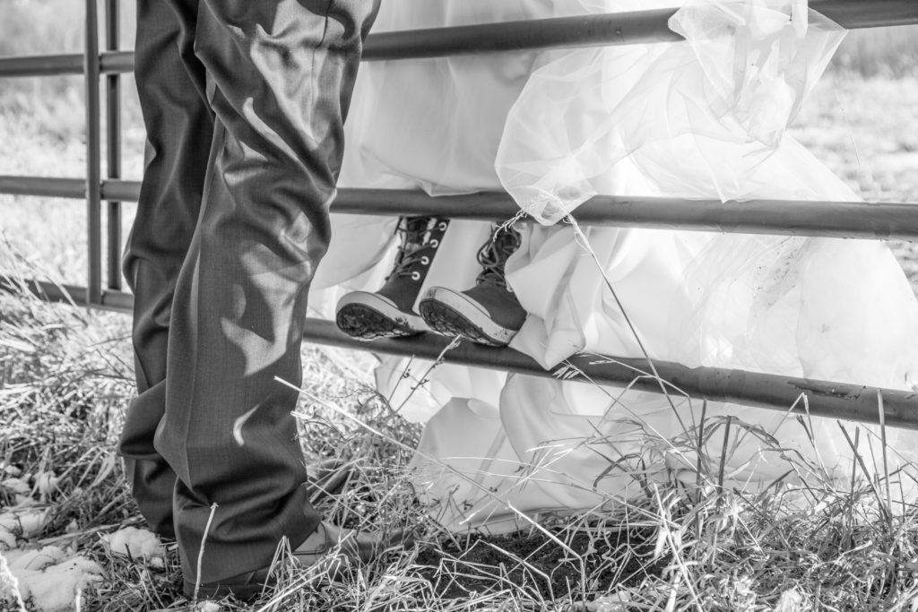 bride & groom on gate with bride wearing snowboots