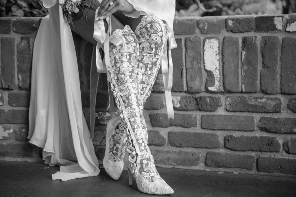 white lace boots against a brick wall