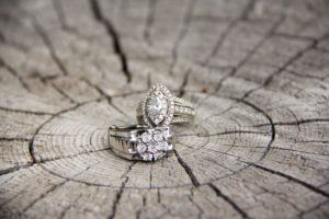 sparkly wedding rings on cracked wooden log