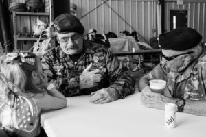 two war veterans talking to a little girl in fairy wings